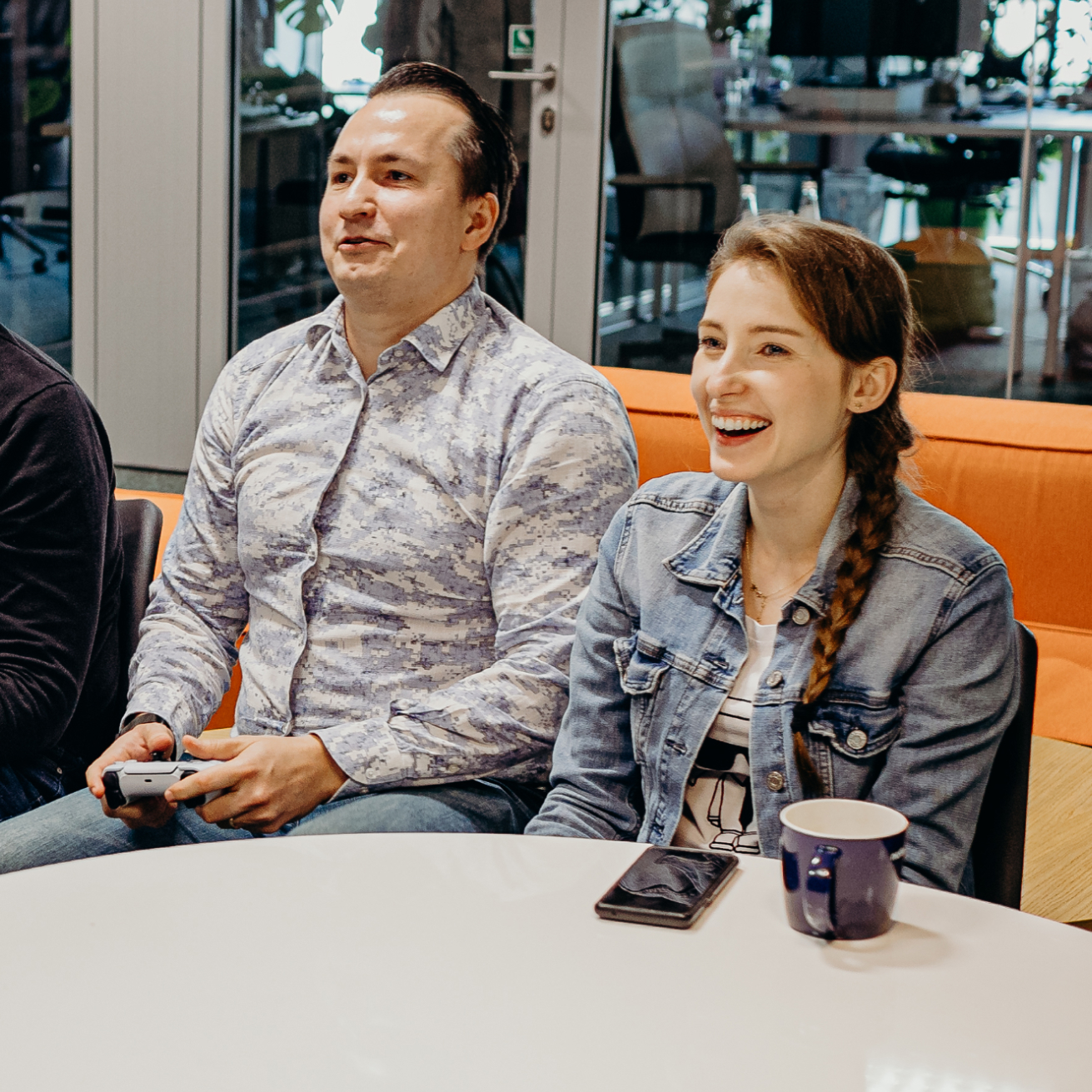 A man and a woman playing a game on PlayStation, enjoying their time together