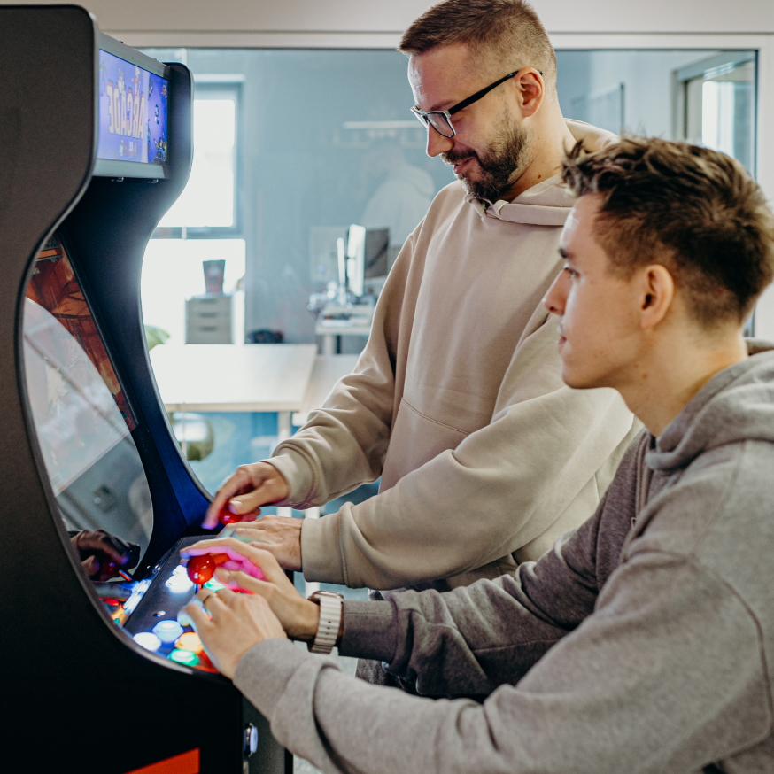 Guys playing on a slot machine - arcade