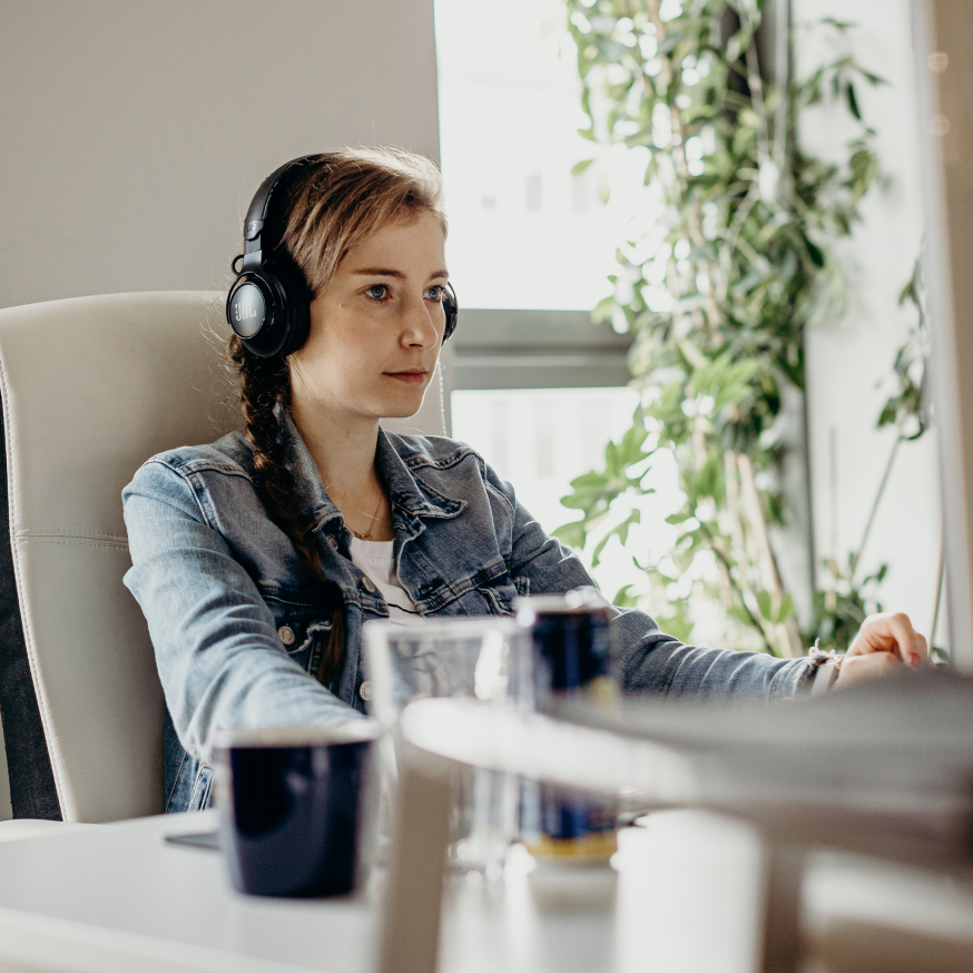 Agata, Frontend Engineer looking at the monitor with headphones on