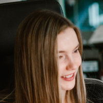 A designer sitting in an armchair, looking at the monitor with a smile on her face